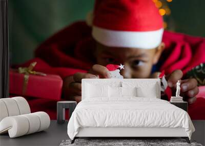 Little Asian Boy Hold Santa Icon on the Bed in Christmas 's Day. Wall mural