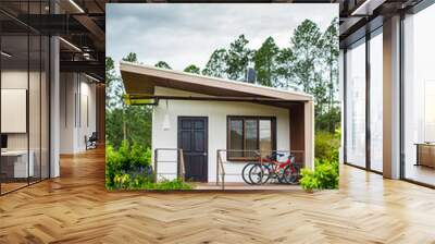 Rustic house with two bycicles and flowers in the garden Wall mural