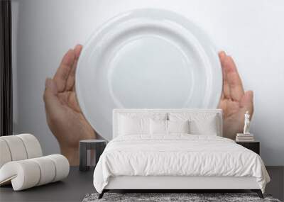 Male hands are holding a plate on a white isolated background Wall mural