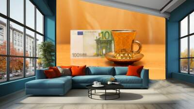 Cup and saucer, 100 euro, golden background, orange table. Drink some tea. The focus on the cup. Wall mural