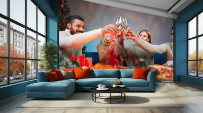 Friends toasting with champagne celebrating Christmas eve dinner party Wall mural