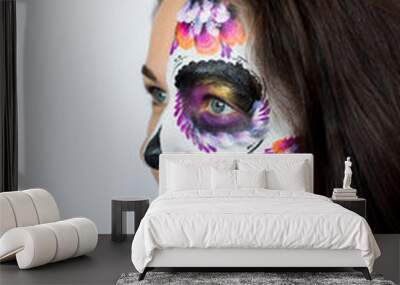 Sugar Skull Halloween Makeup.  Dia de los Muertos. Brunette girl with Mexican style Halloween face painting. Red rose, flower hair decor Wall mural