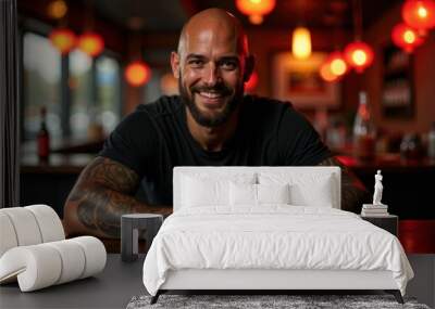 A tattooed man is sitting at a table in a restaurant Wall mural