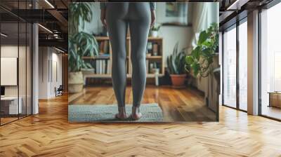 A woman is standing in a cozy living room surrounded by various plants Wall mural