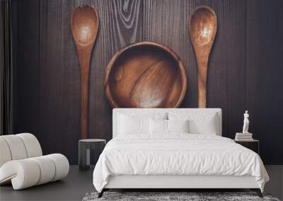 wooden salad bowl and two spoons on the brown table Wall mural