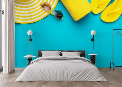 yellow beach accessories on turquoise blue background - sunglasses, towel. flip-flops and striped hat. summer is coming concept with copy space. holiday by the sea concept. Wall mural