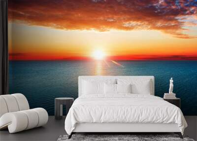 Aerial view of sun rising over sea. Wall mural