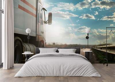 Arriving white truck on the road in a rural landscape at sunset Wall mural