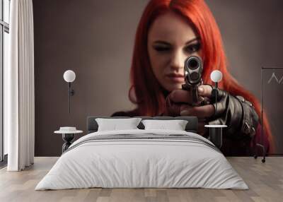 beautiful woman aim with pistol isolated on gray background Wall mural