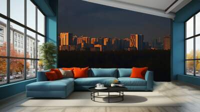 The rays of the morning sun illuminate the city's residential buildings in orange Wall mural