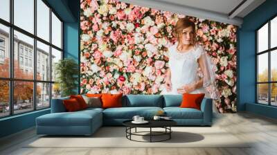 beautiful bride on the background of a wall of flowers Wall mural