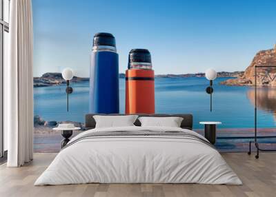 two colored thermos on the background of the sea bay Wall mural