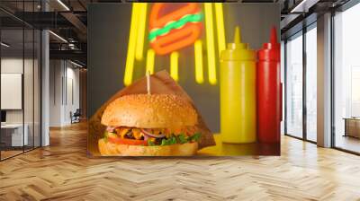 fast food concept of hamburger with two bottles of sauce on neon burger light in night cafe Wall mural