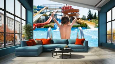 healthy happy little kid near blue swimming pool in water park with water tube slides in summer Wall mural