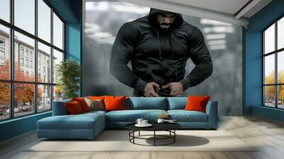 sport mind male motivation concept of epic movie hero strong bearded man in hoodie preparing for weight lifting during indoor gym workout training Wall mural