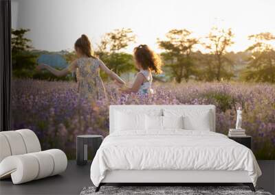 two healthy running little girls among blossom flower fields in summer Wall mural