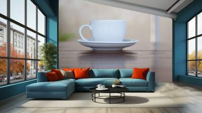 A white cup of coffee placed on a wooden table by the window in a coffee shop, Concept: Delicious breakfast drinks fragrant suitable for lifestyle, closeup cup of coffee over the top with space Wall mural