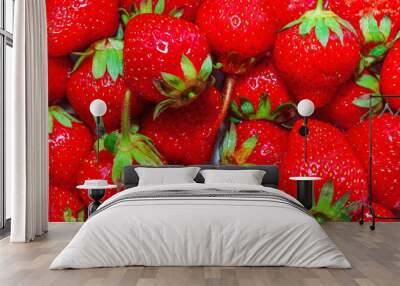 Bunch of red strawberries with green leaves. The strawberries are fresh and ripe. Concept of abundance and freshness Wall mural