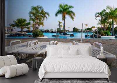 Sun loungers by the swimming pool in luxury hotel resort Wall mural