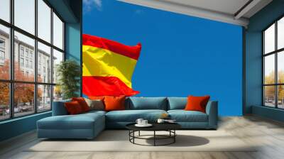 Flag of Spain waving in the wind on flagpole against the sky with clouds on sunny day, banner, close-up Wall mural