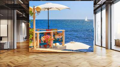 Seaside landscape - view of the cafe on the embankment against the background of the sea with sailboat, in the Nesebar, on the Black Sea coast of Bulgaria Wall mural