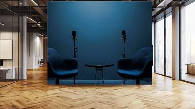 Two chairs and a table in front of a blue wall with a microphone on a stand. Wall mural