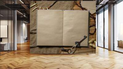 An empty book. There is a place for an inscription or logo. Book with old paper. Book on a wooden surface Wall mural