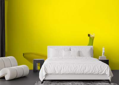 Banana on a yellow background. Fresh yellow banana. One banana in the center of the frame. Exotic fruit Wall mural