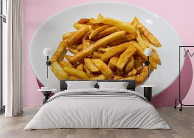 French fries on a white plate on a pink background. A delicious way to cook potatoes. Delicious fast food Wall mural