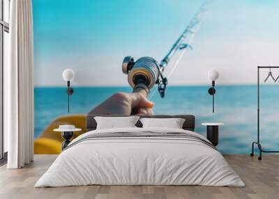 Fisherman holding fishing rod over blue ocean water Wall mural