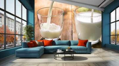 split milk from a glass on wooden table Wall mural