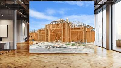 Unfinished new single family residential homes under construction at wood frame under blue skies in south Florida Wall mural