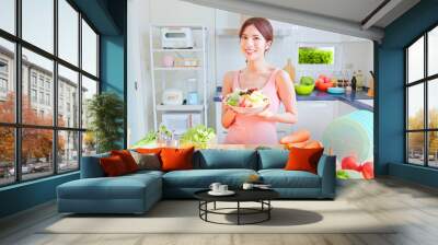 female holding salad in kitchen Wall mural