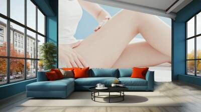 woman apply cream with leg Wall mural