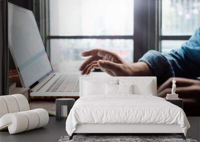 Close-up of male hands with laptop. Man is working remotely at home. Freelancer at work Wall mural