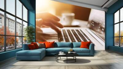 Close-up photo of male hands with laptop. Man is working remotely at home Wall mural