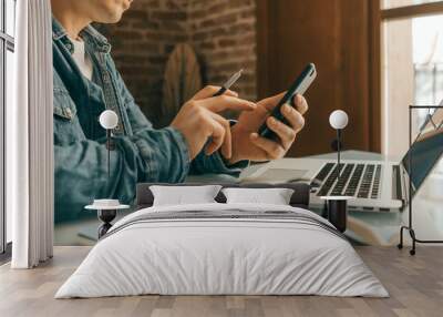 Man pointing on smartphone screen, chatting in social networks, meeting website, searching internet, using text messenger or online banking. Close up of male hands. Remote work Wall mural