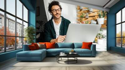 Man with laptop working remotely from home Wall mural