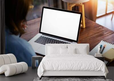 Mockup image of a woman using laptop with blank screen on wooden table Wall mural