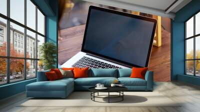 Mockup image of a woman using laptop with blank screen on wooden table Wall mural