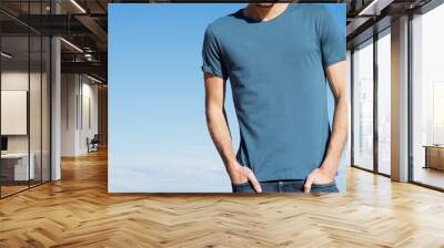 Photo of a man wearing blue t-shirt. Blue sky on background Wall mural