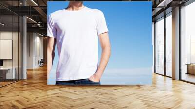 Photo of a man wearing white t-shirt. Blue sky on background Wall mural