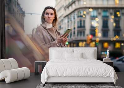 Young woman with smartphone on night street Wall mural