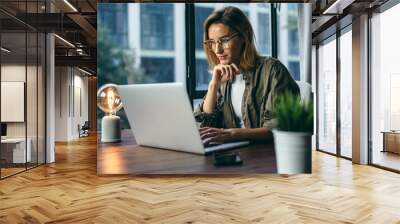 young woman working with a laptop. female freelancer connecting to internet via computer. businesswo Wall mural