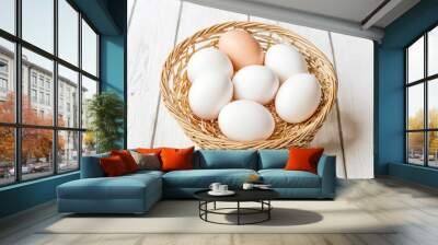 Fresh white eggs in a wicker basket on white wooden background Wall mural