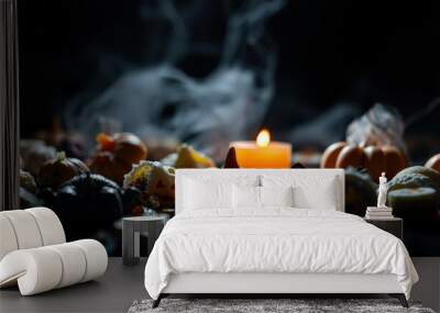 lit candle amidst halloween decor Wall mural