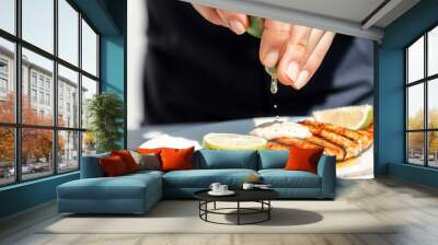 Squeezing Lime Juice Over Grilled Fish Wall mural