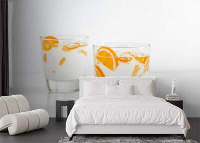 Two glasses of milk with orange slices on a white background Wall mural