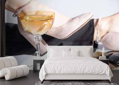 Fashion and style concept. Fancy accessories, casino tokens, sunglasses, jewelry and drink placed on table. Woman legs with black trousers and pink high heel shoes in background Wall mural