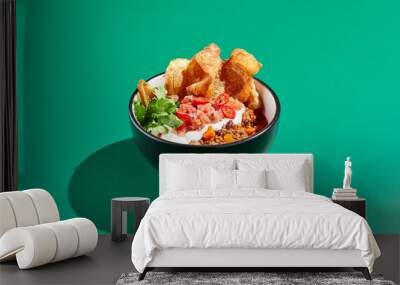 Chili con carne on colour background with hard shadow. Mexican chili in minimal style on green table. Traditional mexican cuisine on trendy design. Chili soup in bowl contemporary concept. Wall mural